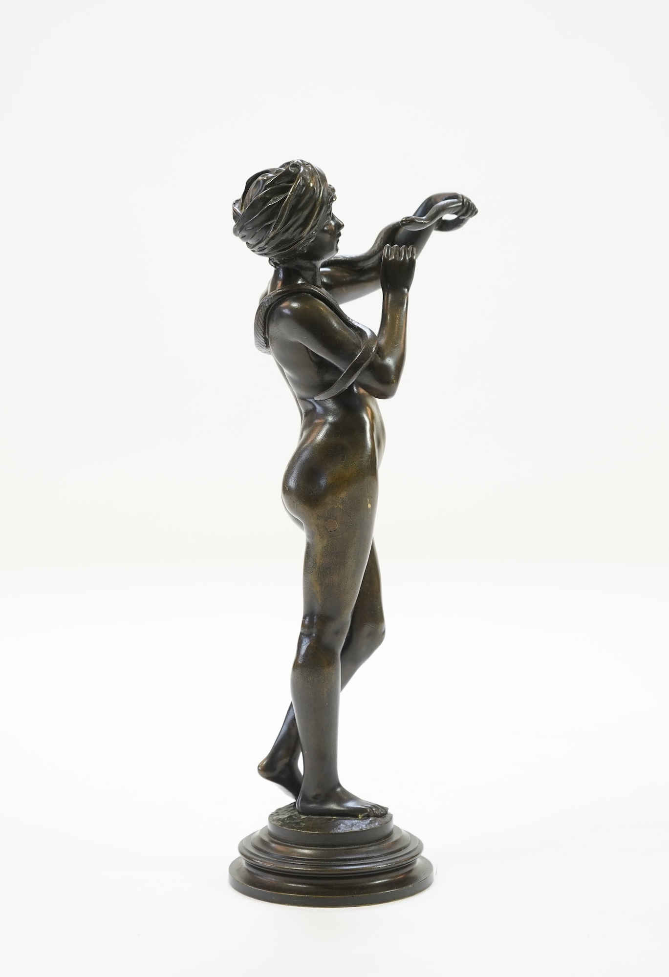 Josef Wind (German, 1864-1889). A patinated bronze of a nude female snake charmer